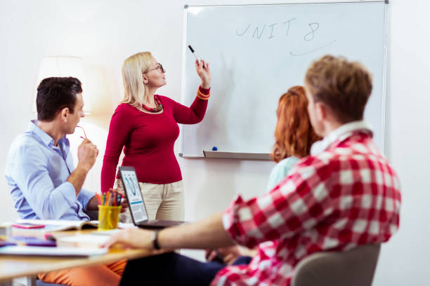 istock Nice pleasant woman pointing at the whiteboard 1143326576