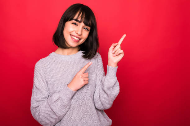 istock Young brunette Woman showing pointing on red background. 1143328783