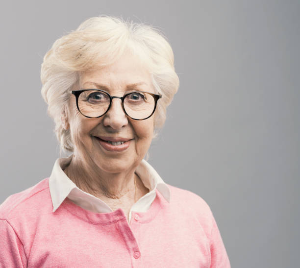 istock Happy senior woman posing on gray background 1143332050