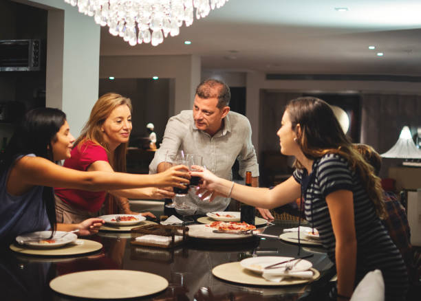 istock Family together toasting at a dinner table and eating pizza 1143332716