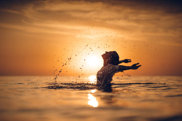 夕暮れ時の海の美しさ - sea swimming greece women ストックフォトと画像