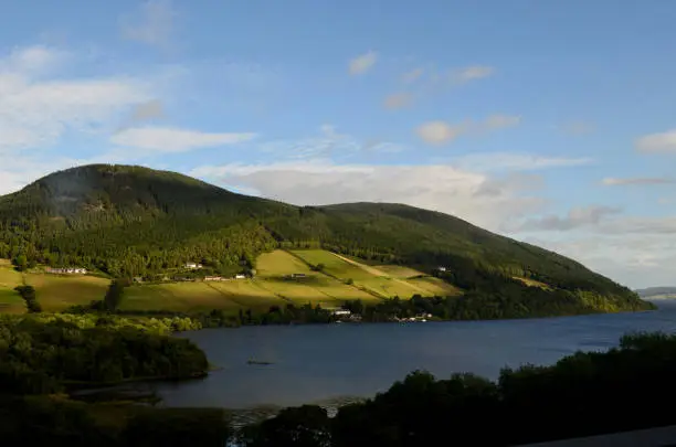 Scotland's intriguing Loch Ness surrounded by rolling green hills.