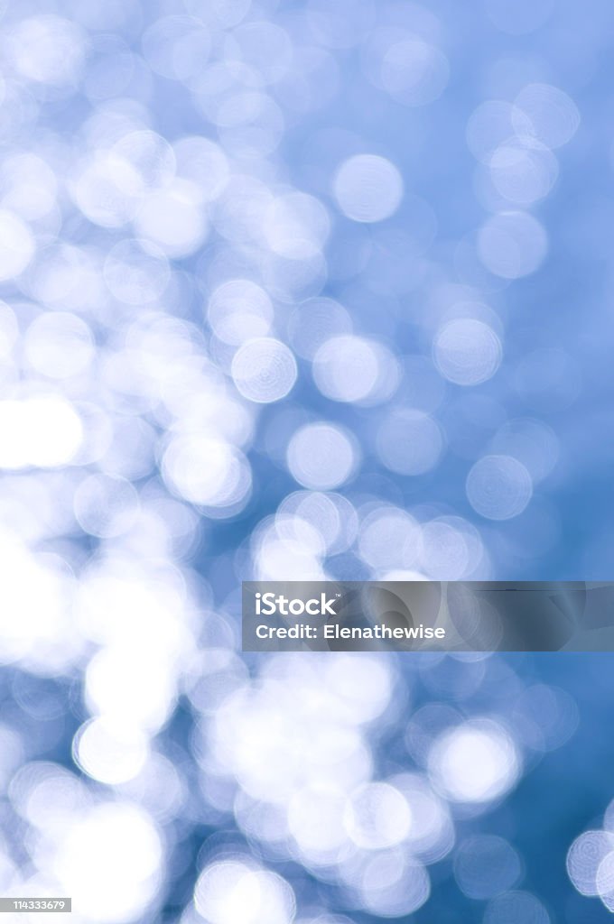 Blue and white background Out of focus bokeh background of blue water with sun reflections. Can be used as Christmas or winter backdrop. Abstract Stock Photo