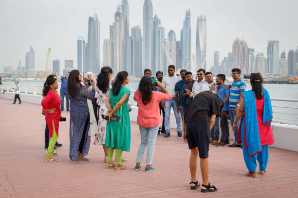 Tourists from India are photographed against the backdrop of beautiful and tall buildings of the city stock photo