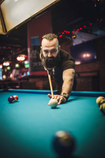 istock Man with long beard playing snooker in a pub 1143347999