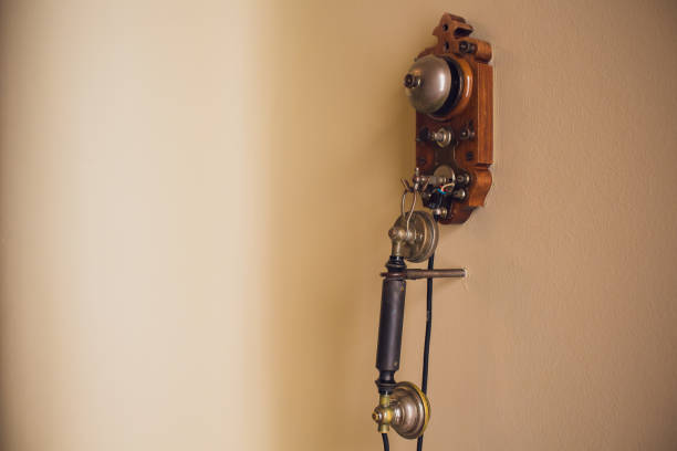 istock Old retro wood telephone on a beige white wall. 1143350038