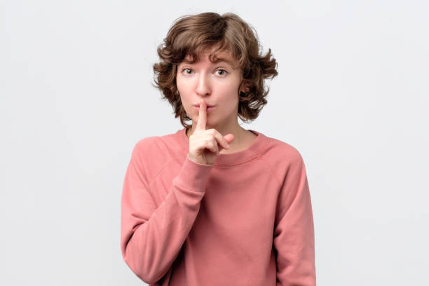 istock Keep it in secret. Curly female asks to keep secret information confidential 1143352055