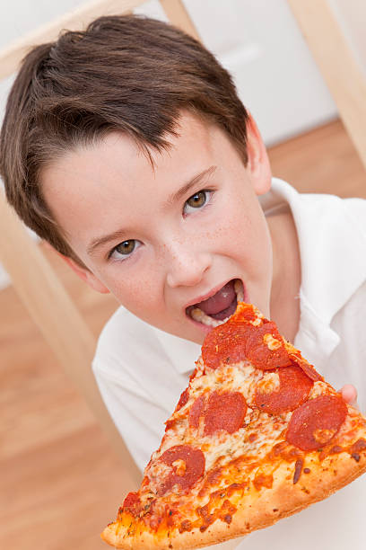 istock Young Boy Child Eating Slice of Pizza 114335461
