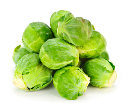 Stock photo showing a group of fresh green Brussels sprouts being sold in a fruit and vegetable store.