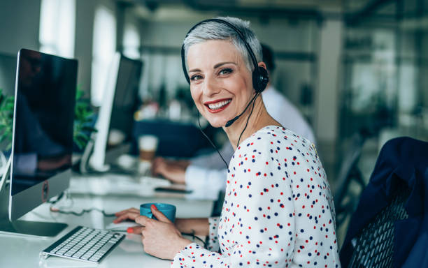 respondendo a sua chamada com um sorriso - female customer service representative looking at camera technology - fotografias e filmes do acervo