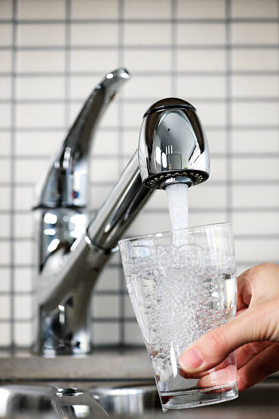 istock Glass being filled under a kitchen faucet with tap water 114336176