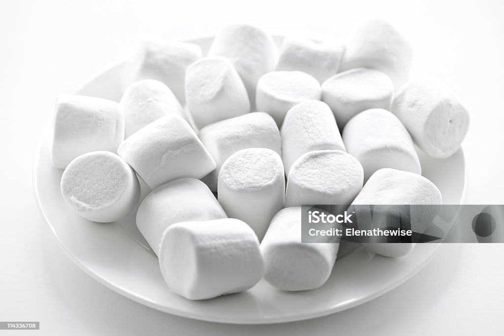 A pile of marshmallows on a plate  Close up of many plump sweet marshmallows on plate Candy Stock Photo