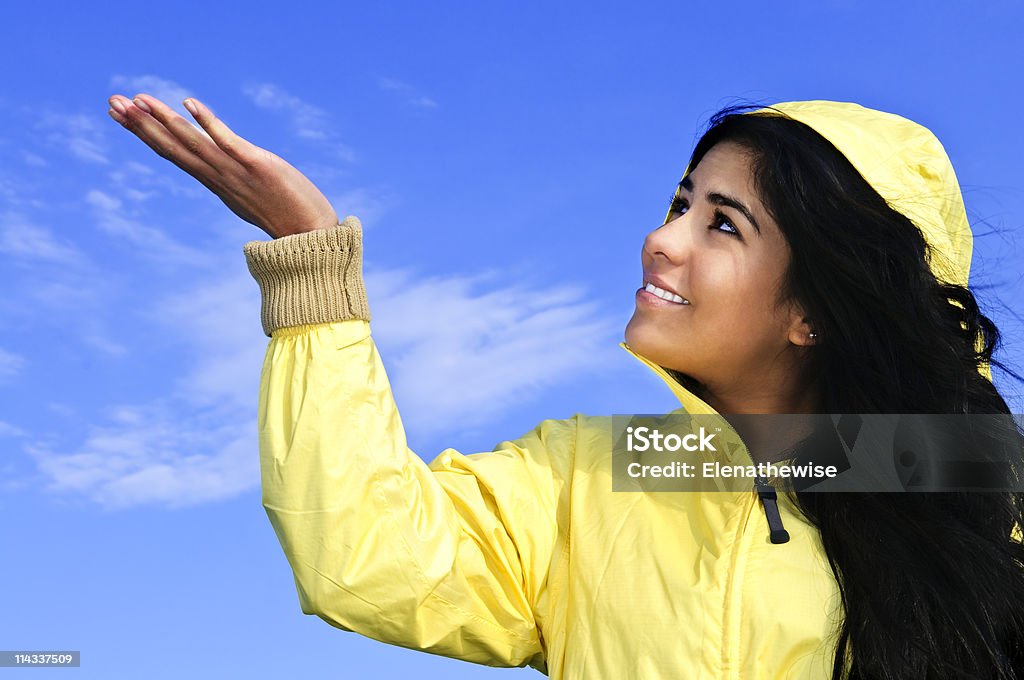 Beautiful young woman in raincoat checking for rain  Adult Stock Photo