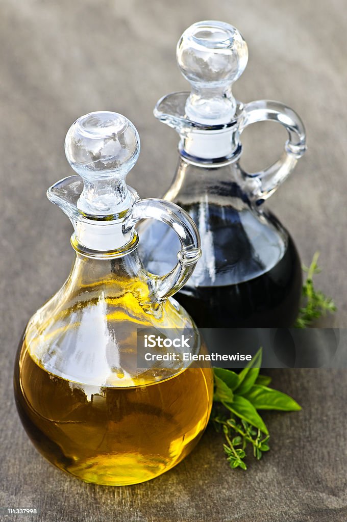 Bottles of oil and vinegar on wooden table Oil and balsamic vinegar glass bottles with spouts Bottle Stock Photo