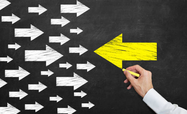 istock yellow arrow leading to different direction on the blackboard with chalk 1143380123