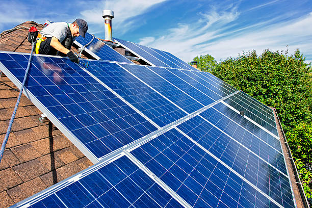 Solar panel installation Man installing alternative energy photovoltaic solar panels on roof rooftop solar stock pictures, royalty-free photos & images