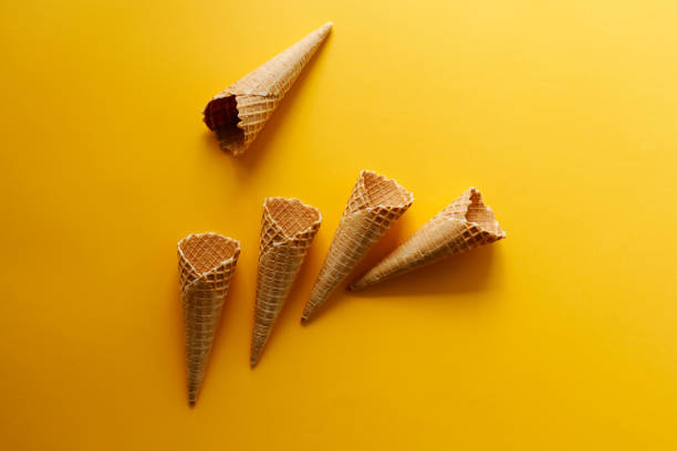istock Empty wafer ice cream cones on yellow background 1143381492