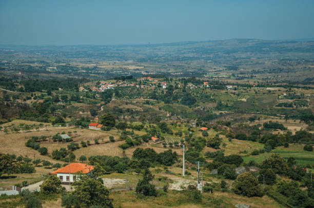 istock Countryside landscape with trees and cottage roofs 1143385647
