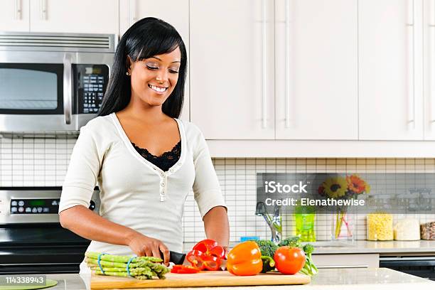 A Young Woman Cutting Vegetables In A Kitchen Stock Photo - Download Image Now - Cooking, Healthy Eating, Healthy Lifestyle