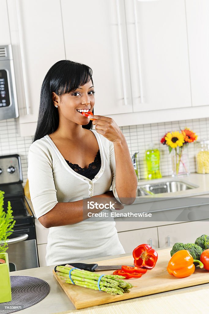 若い女性のテイスティング野菜のキッチン - 1人のロイヤリティフリーストックフォト