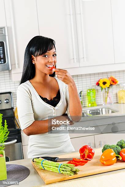 若い女性のテイスティング野菜のキッチン - 1人のストックフォトや画像を多数ご用意 - 1人, おやつ, まな板