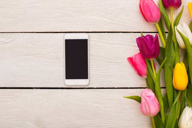 istock Spring decorations flowers isolated on wooden background smartphone 1143390323