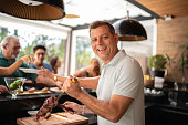 Portrait of man cutting picanha meat during barbecue