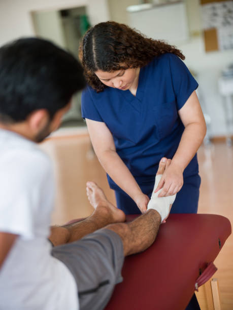 istock Female nurse wrapping patient's ankle with bandage 1143400912