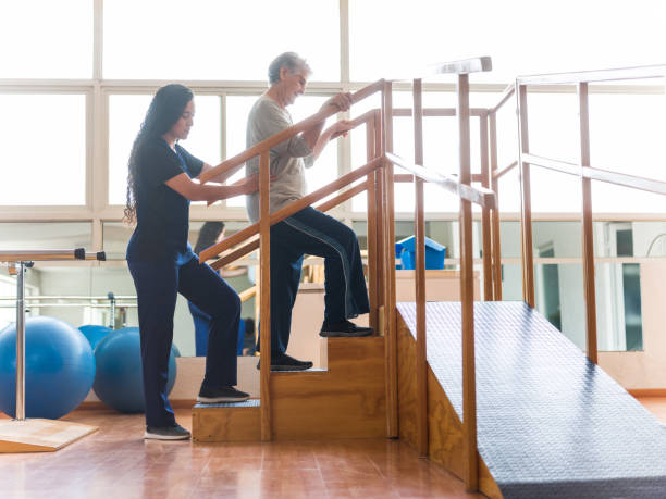 leitere patientin, die schritte in der physiotherapie aufnimmt - scrubs professional sport indoors healthcare and medicine stock-fotos und bilder