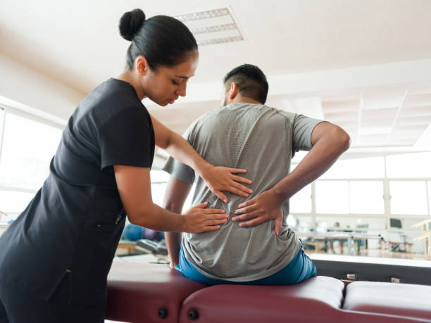 Female massage therapist massaging patient's back