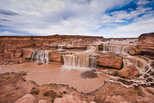 Grand Falls is on the Little Colorado River near Leupp, Arizona, USA. The falls typically flow when there is heavy snowmelt in the spring and during the monsoon rains of late summer. Due to its dark brown color, Grand Falls is often called Chocolate Falls. The headwaters of the Little Colorado River are far to the south in the White Mountains of Southeast Arizona. The Little Colorado is a tributary of the Colorado River which starts in the Rocky Mountains of Colorado. The confluence of the two rivers is in nearby Grand Canyon National Park.