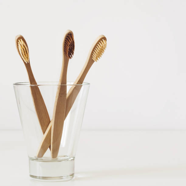 istock Natural bamboo toothbrushes in glass on white bathroom table 1143410966