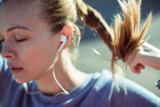 Getting Ready Close up of a woman tying her hair before jogging woman tying hair in ponytail getting ready for exercising stock pictures, royalty-free photos & images