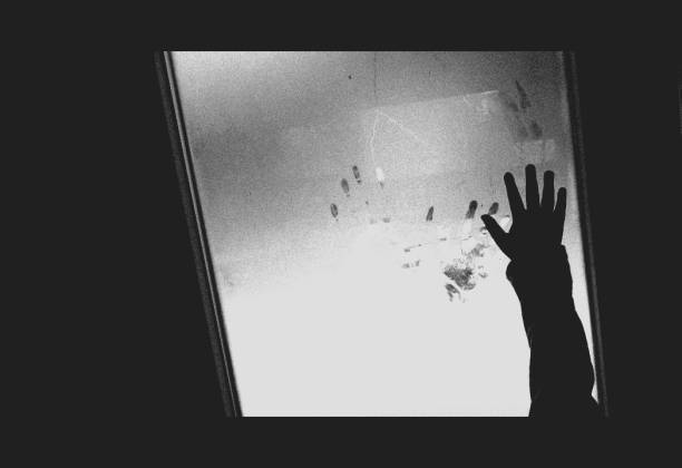 istock Childrens hand on the misted (frozen) window, black and white photos, back view 1143412418