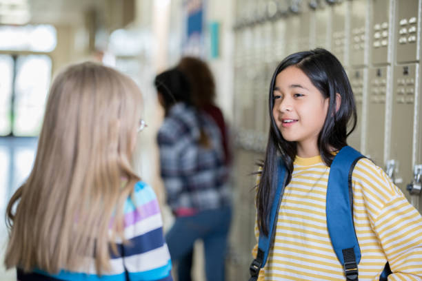 istock Two middle school girls talking near lockers 1143416832