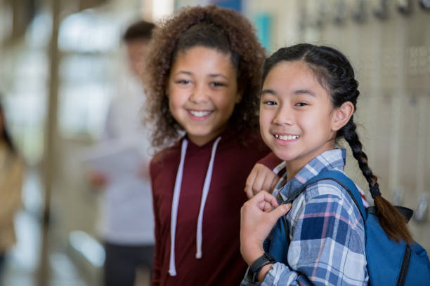 istock Middle school girls smiling in corridor 1143416834