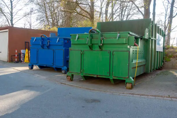 Photo of two garbage compactors are standing in the courtyard of a hospital