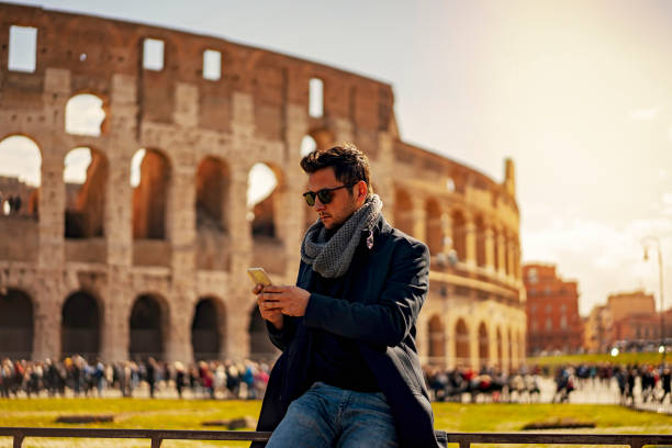 Man writing a message in front of the Coliseum in Rome