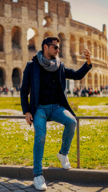 istock Man doing video conversation in front of the Roma Colosseum 1143421603