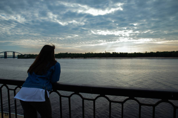istock woman looking on sunrise over the river. 1143424168