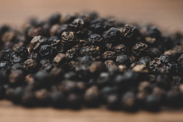 istock Black pepper isolated on wood background 1143424262