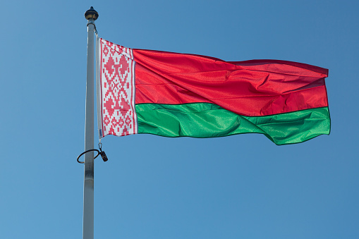 The Flag of Belarus close up with a blue sky.
