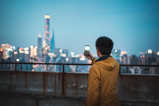 A Young Man Is Using a mobile phone on the Rooftop