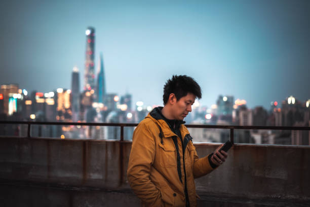 A Young Man Is Using a mobile phone on the Rooftop