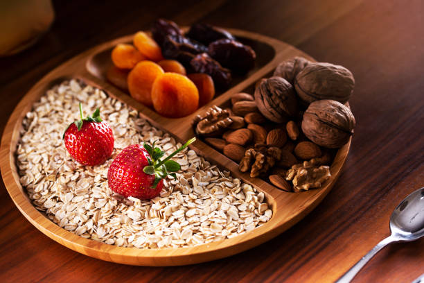 Healthy breakfast. Bamboo bowl with granola, strawberry, walnut, almonds, dry fruits and yogurt. Diet and vegetarian food concept.