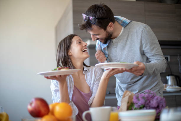 istock Young couple with vegan breakfast in dining room holds tablet 1143429142