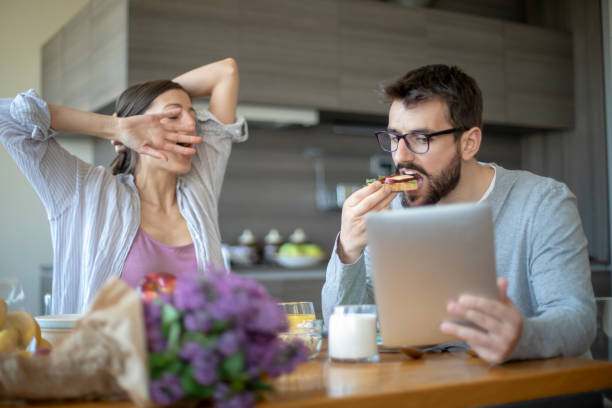istock Young couple with vegan breakfast in dining room and holds tablet 1143429183