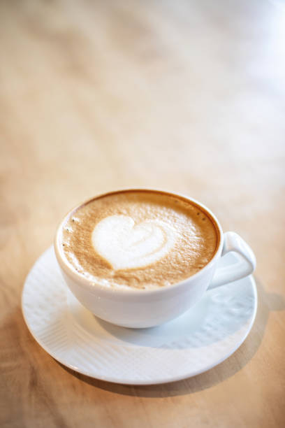 istock White cappuccino cup on light brown wood background 1143429308
