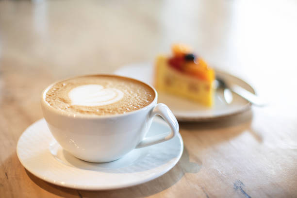 istock White cappuccino cup and dessert on light brown wood background 1143429312