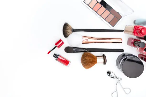 Photo of Decorative cosmetics, makeup products and brushes on a white background